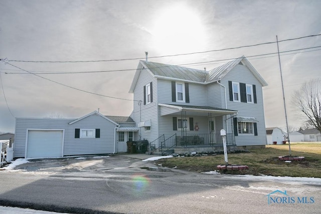 view of front facade with an attached garage, covered porch, driveway, and metal roof