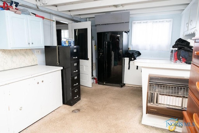 kitchen with white cabinets, light countertops, and black refrigerator with ice dispenser