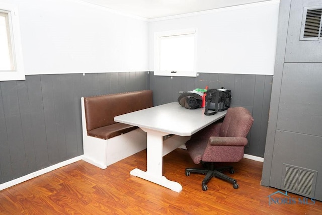 office with a wainscoted wall, visible vents, and wood finished floors