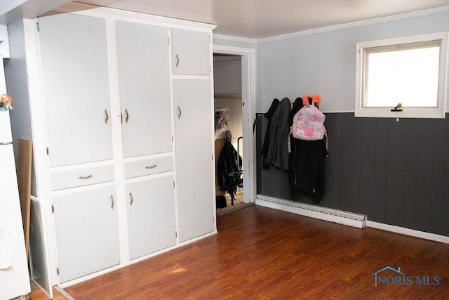 interior space featuring a baseboard heating unit, freestanding refrigerator, crown molding, and wood finished floors