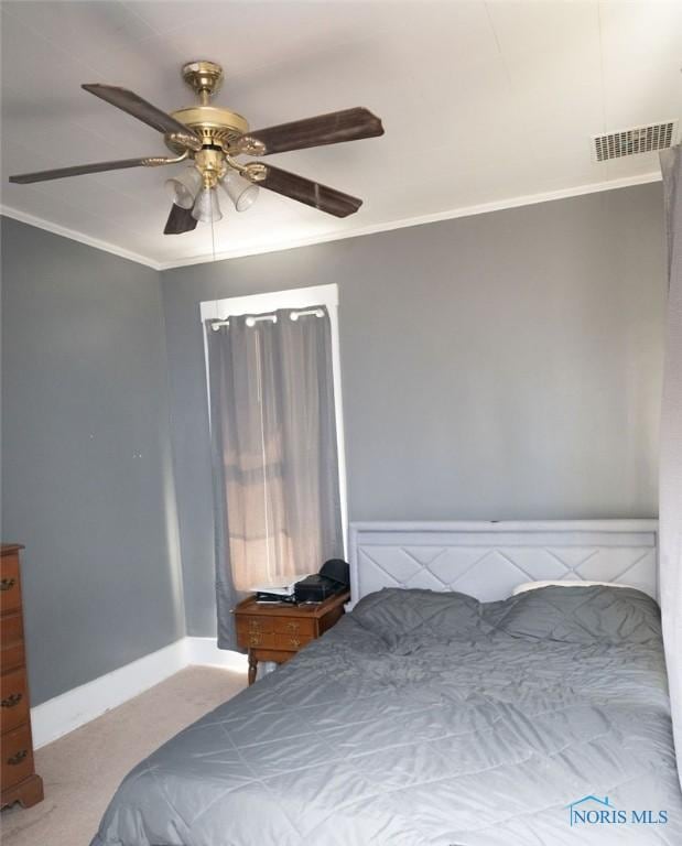 unfurnished bedroom with visible vents, baseboards, a ceiling fan, ornamental molding, and carpet