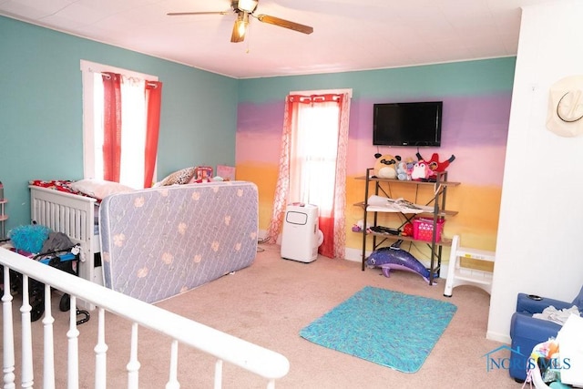 carpeted bedroom with multiple windows and a ceiling fan