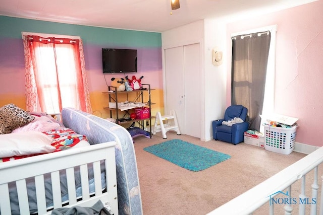 carpeted bedroom featuring a closet and a ceiling fan