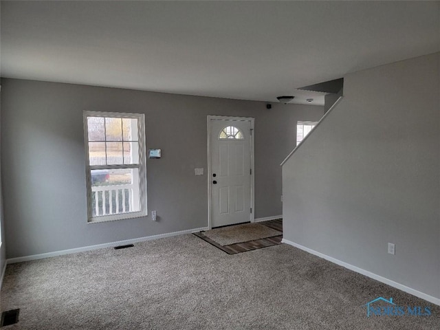 entrance foyer featuring carpet floors, visible vents, and baseboards