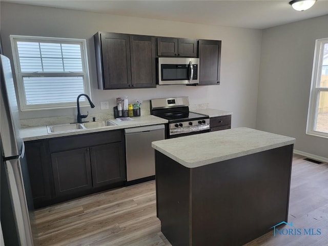 kitchen with light wood finished floors, visible vents, stainless steel appliances, and a sink