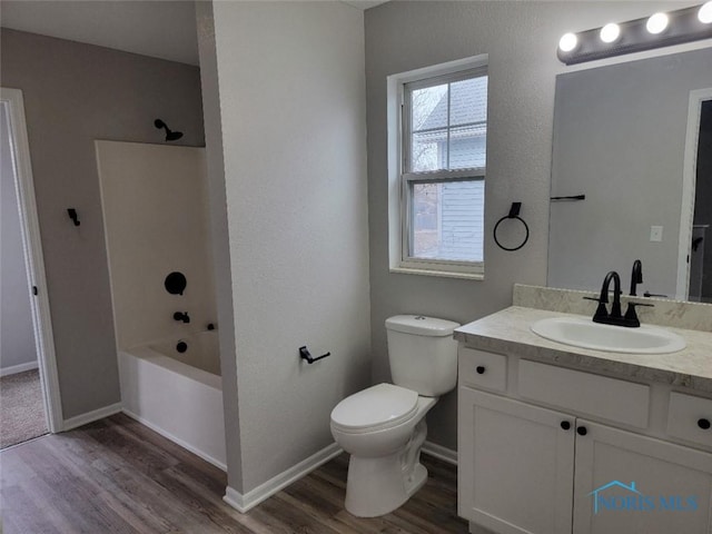 full bath featuring shower / bathtub combination, toilet, wood finished floors, vanity, and baseboards