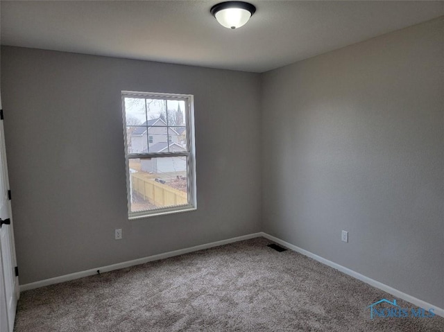 carpeted empty room featuring visible vents and baseboards