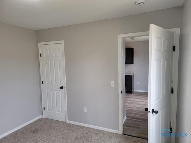 unfurnished bedroom with carpet flooring and baseboards