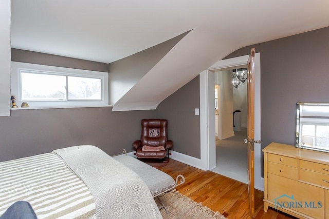 bedroom with light wood-style floors, multiple windows, baseboards, and vaulted ceiling