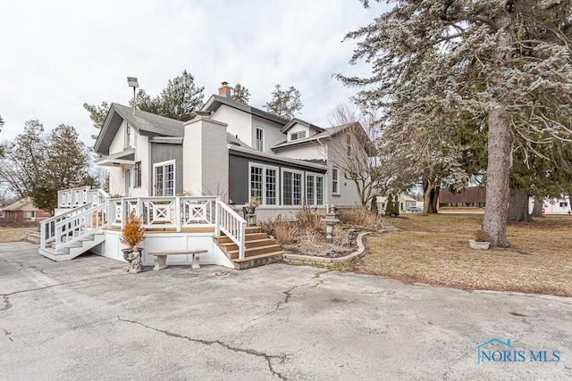 view of front of home with a chimney and a wooden deck