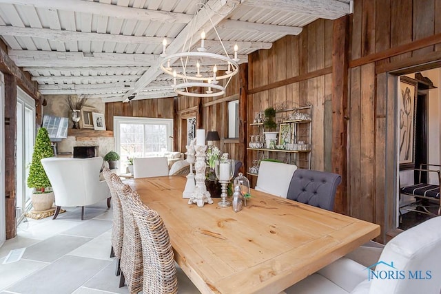 dining room featuring wooden ceiling, an inviting chandelier, and wooden walls