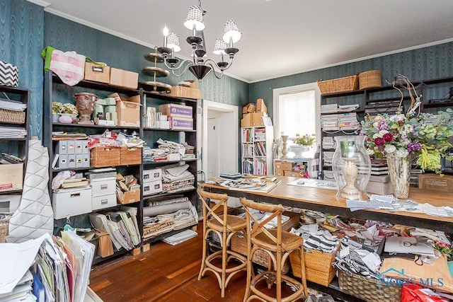 dining room featuring a chandelier, wood finished floors, crown molding, and wallpapered walls