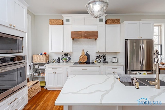 kitchen featuring ornamental molding, appliances with stainless steel finishes, white cabinetry, and tasteful backsplash