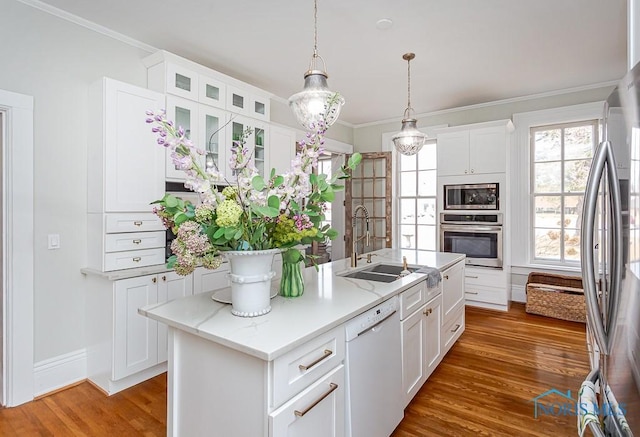 kitchen featuring stainless steel appliances, white cabinetry, a sink, and wood finished floors