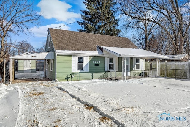 bungalow with a porch, a shingled roof, and fence