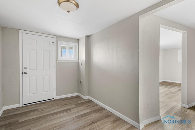 entryway with baseboards and wood finished floors