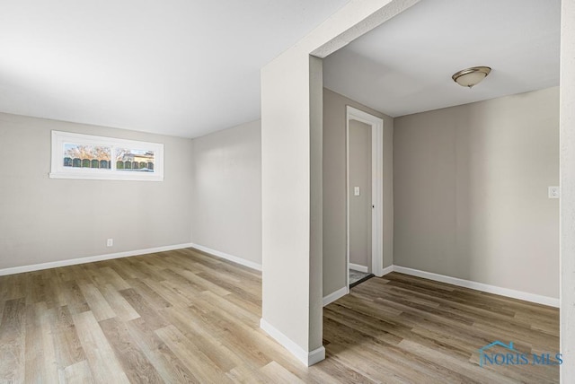 empty room featuring wood finished floors and baseboards