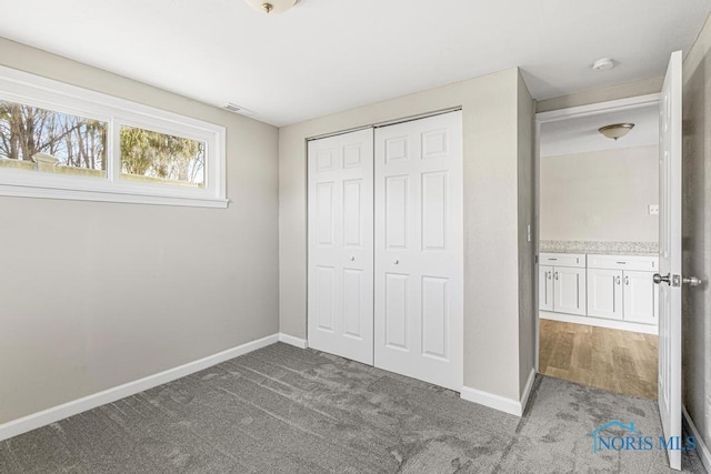 unfurnished bedroom featuring a closet, carpet, and baseboards