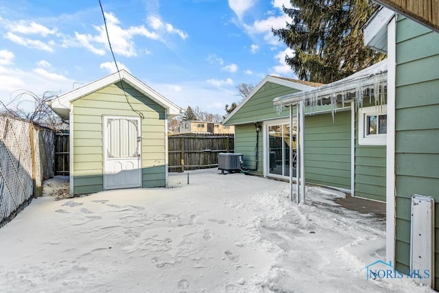 view of patio with an outbuilding, a fenced backyard, central AC unit, and a storage unit