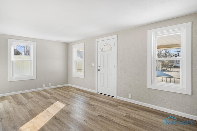 entryway featuring baseboards and wood finished floors