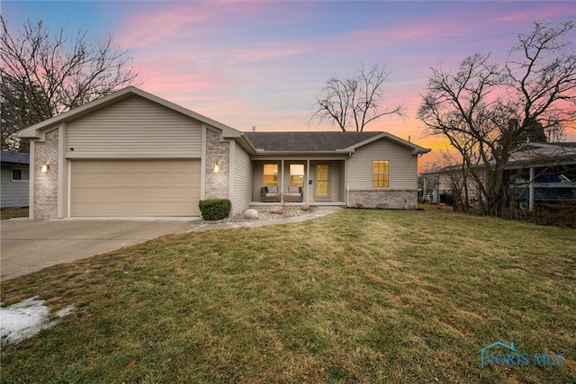 ranch-style house featuring an attached garage, concrete driveway, a lawn, and brick siding