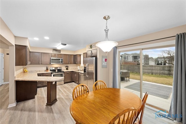 dining area featuring light wood-style floors, baseboards, and recessed lighting