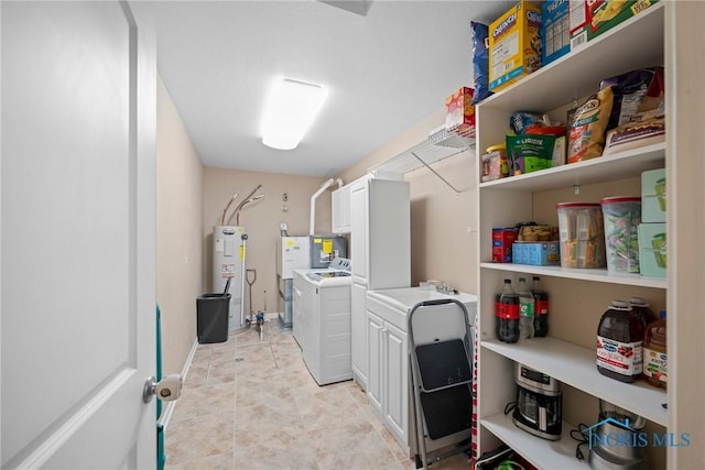 washroom featuring light tile patterned flooring, separate washer and dryer, baseboards, water heater, and cabinet space