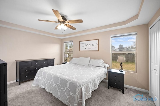 bedroom with light carpet, multiple windows, and baseboards