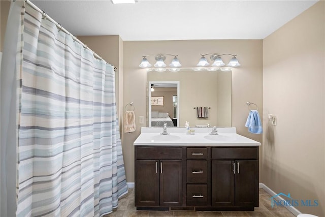 ensuite bathroom featuring double vanity, tile patterned flooring, a sink, and ensuite bathroom