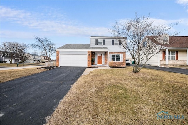 view of front of house featuring a garage, a front yard, brick siding, and driveway