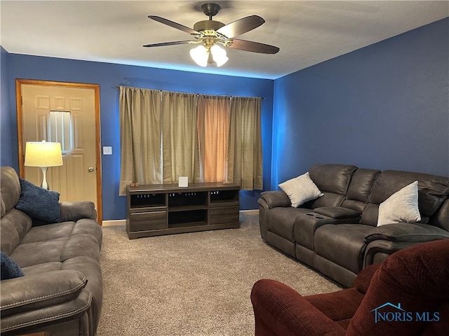 carpeted living room with a ceiling fan and baseboards