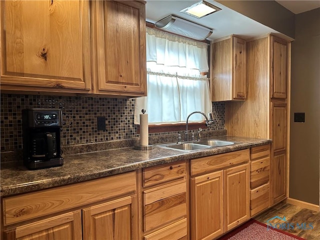 kitchen featuring baseboards, a sink, and decorative backsplash