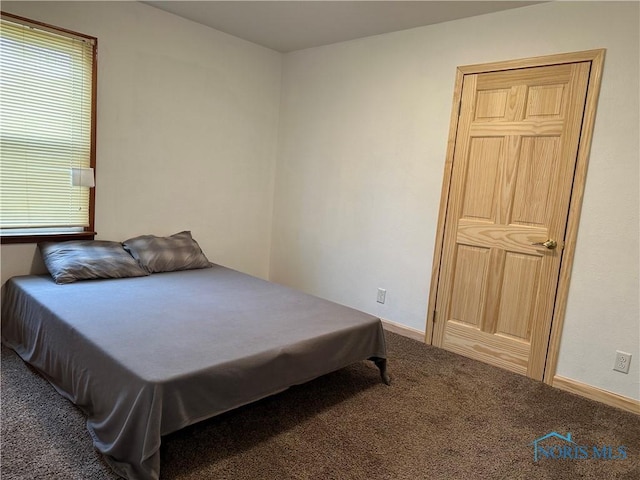 carpeted bedroom with multiple windows and baseboards