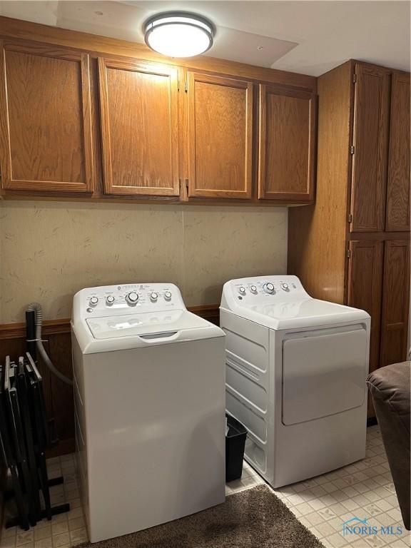 washroom with cabinet space and washer and clothes dryer