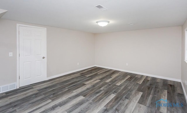 empty room with baseboards, visible vents, and wood finished floors