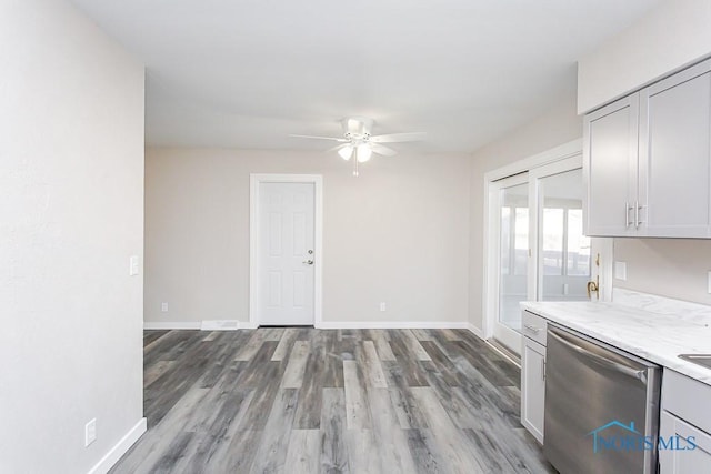 interior space with dishwasher, ceiling fan, light wood-style flooring, and baseboards