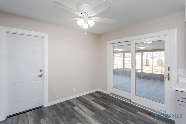 spare room with a ceiling fan, baseboards, and dark wood-type flooring