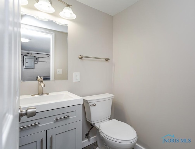 bathroom featuring baseboards, vanity, and toilet