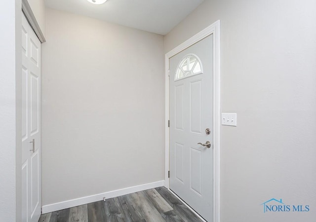 doorway with dark wood finished floors and baseboards