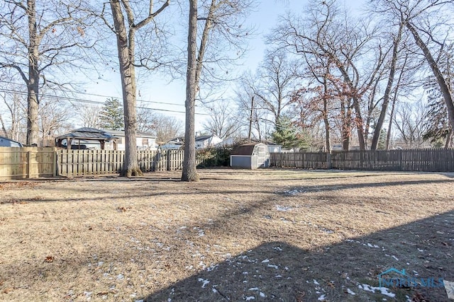 view of yard featuring an outbuilding, a storage unit, and a fenced backyard