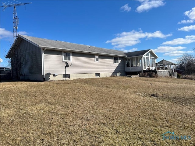 view of home's exterior featuring a sunroom and a yard