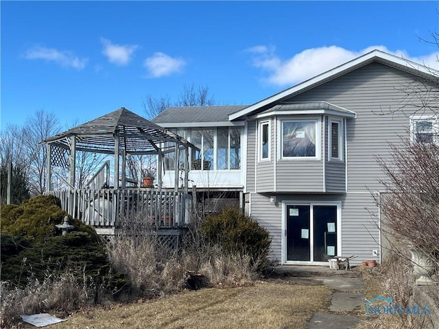 rear view of house featuring a sunroom