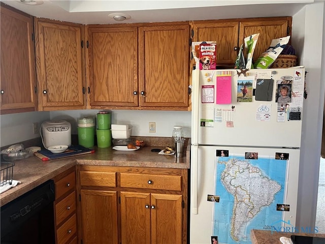 kitchen with freestanding refrigerator, brown cabinets, and dishwasher