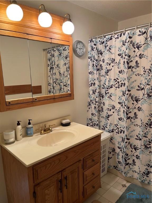 bathroom featuring a shower with shower curtain, vanity, and tile patterned floors