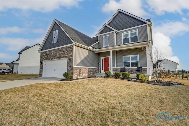 craftsman inspired home featuring covered porch, an attached garage, stone siding, driveway, and a front lawn