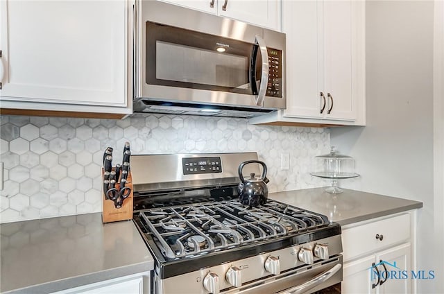 kitchen with appliances with stainless steel finishes, white cabinetry, and decorative backsplash