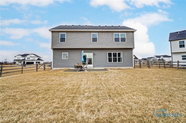 rear view of property featuring a gate, a fenced backyard, a patio, and a lawn