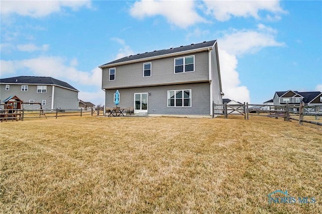 rear view of property with a lawn, a patio area, and a fenced backyard