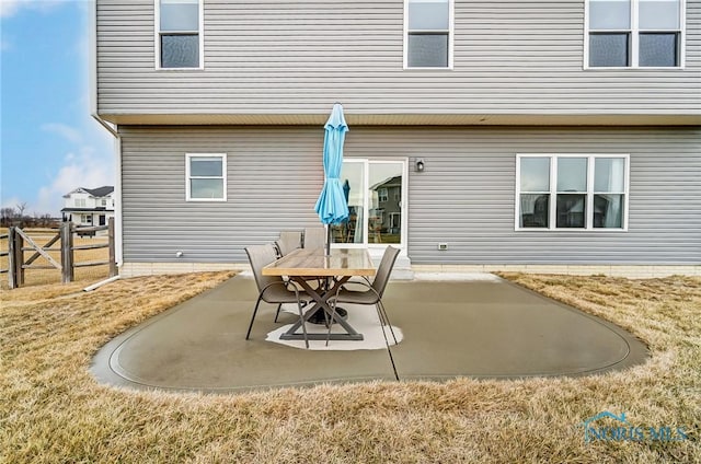 rear view of property with fence, a lawn, and a patio