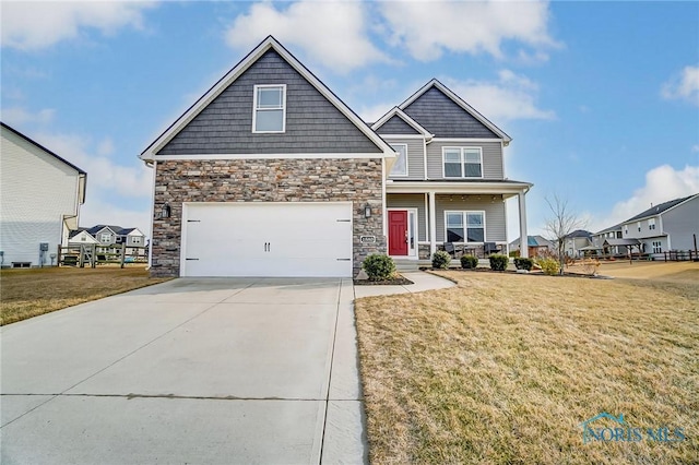 craftsman house with driveway, a garage, stone siding, covered porch, and a front lawn